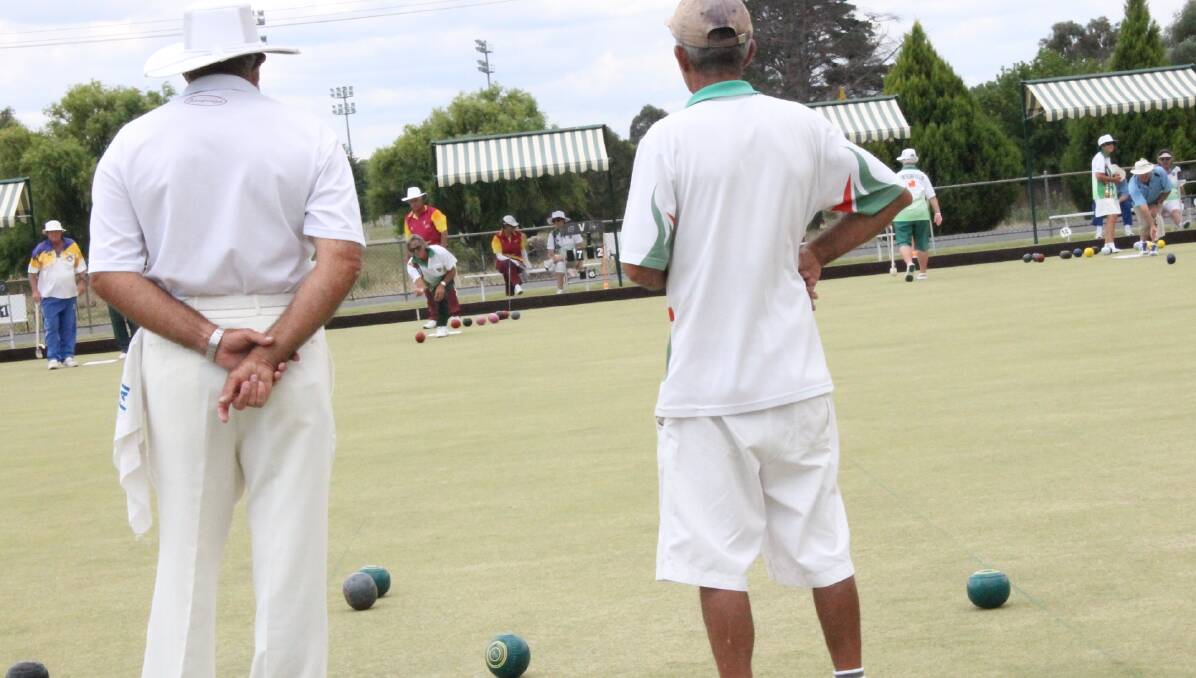 Tenterfield skip Allan Bancroft and eventual winner Mick O'Leary of Tannymorel watch Dave Smith's bowl in the triples on Thursday.
