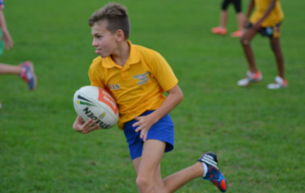 Taj Cusack makes a run on the way to his team winning the junior touch football grand final.