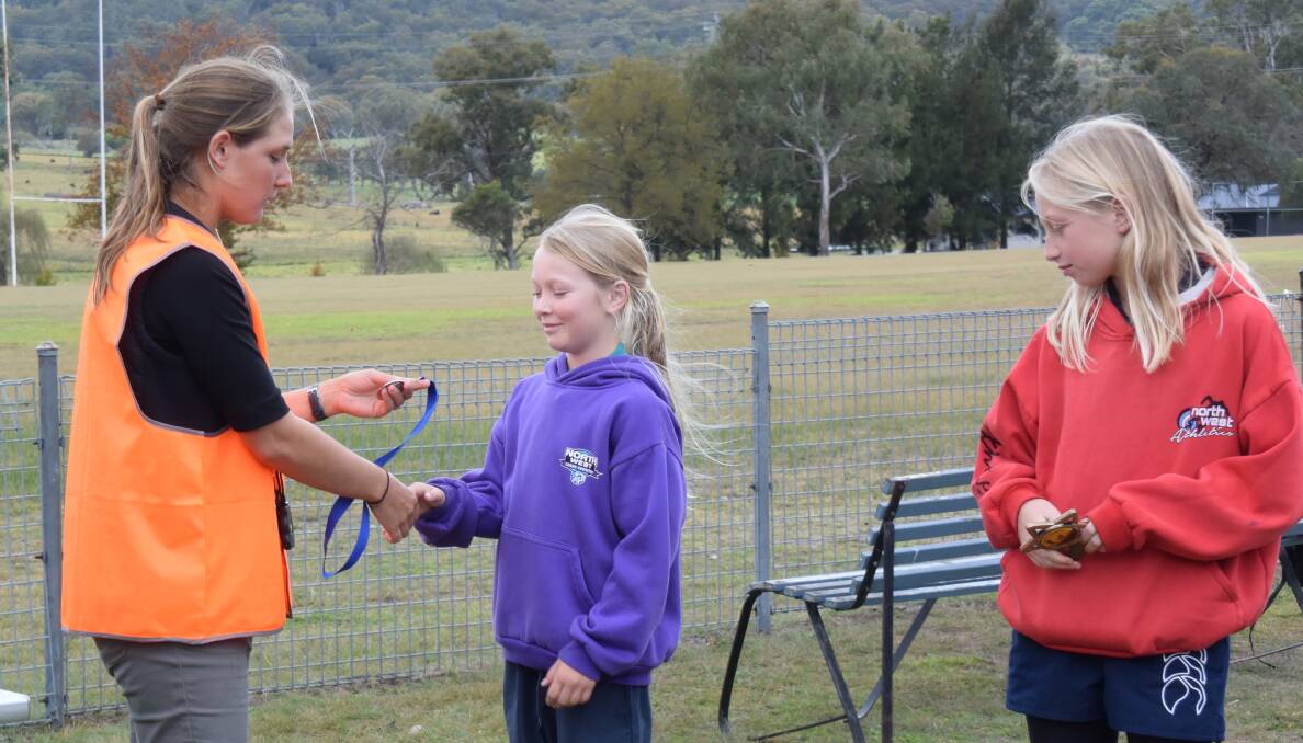 Emily Ryan presents Summer Cooper with her runner-up medallion for the 11 years girls, as winner Maisie Eastood looks on, for another GIPS clean sweep.