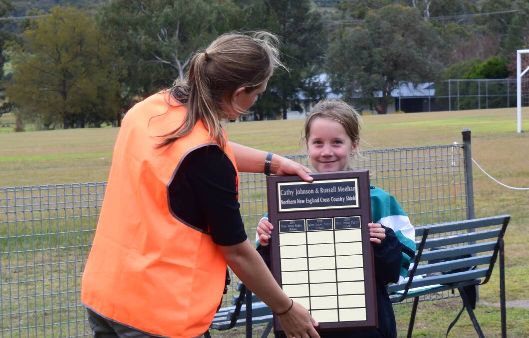 GIPS took home the Cathy Johnson and Russell Meehan Northern New England Cross Country Shield, seen here being presented to student Charli Lynn by event coordinator Emily Ryan.