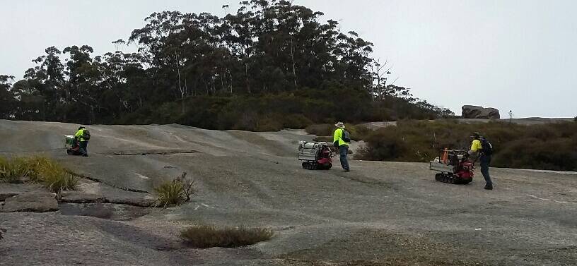HARD DAY'S WORK: National Parks and Wildlife Service workers use motorised wheelbarrows for the daunting task of erecting better signage for those opting to climb Bald Rock.