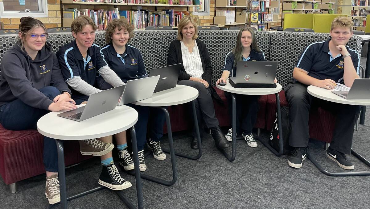 Tenterfield High School principal Stephanie Scott with some of the Year 11 students studying on their laptops following a letter the school's HSC results are improving dramatically. 