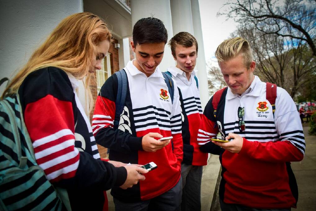 OUTSIDE ONLY: Sophie Myhill, Jack Roussos and Jack Staader, and Harry Jorgensen check for activity on the school's front steps. A Rattata appeared in the staff common room, but their teacher, Dayne Rosolen, set a blanket rule: No Pokemon chasing in class.