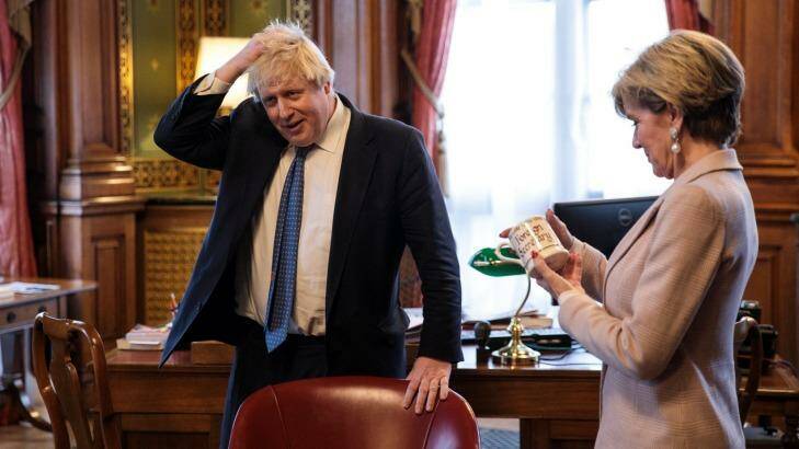 British Foreign Secretary Boris Johnson rubs his head as his Australian counterpart Foreign Minister Julie Bishop inspects his mug which reads 'Foreign Secretary' in his office. Photo: Jack Taylor