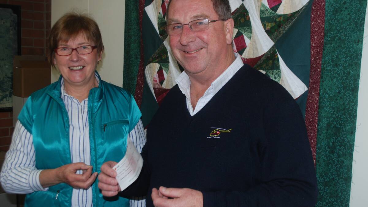 Pam Hartfield hands over a cheque to Westpac Helicopter Service support group committee member Michael Jones.