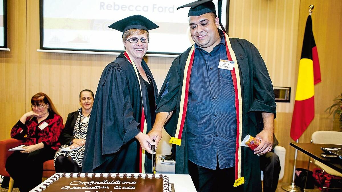 Party time: Rebecca Ford shares the honour with Kurt Simpson of cutting the celebratory cake for the graduating class of Aboriginal Health Practitioners at Sydney's Aboriginal Health College.