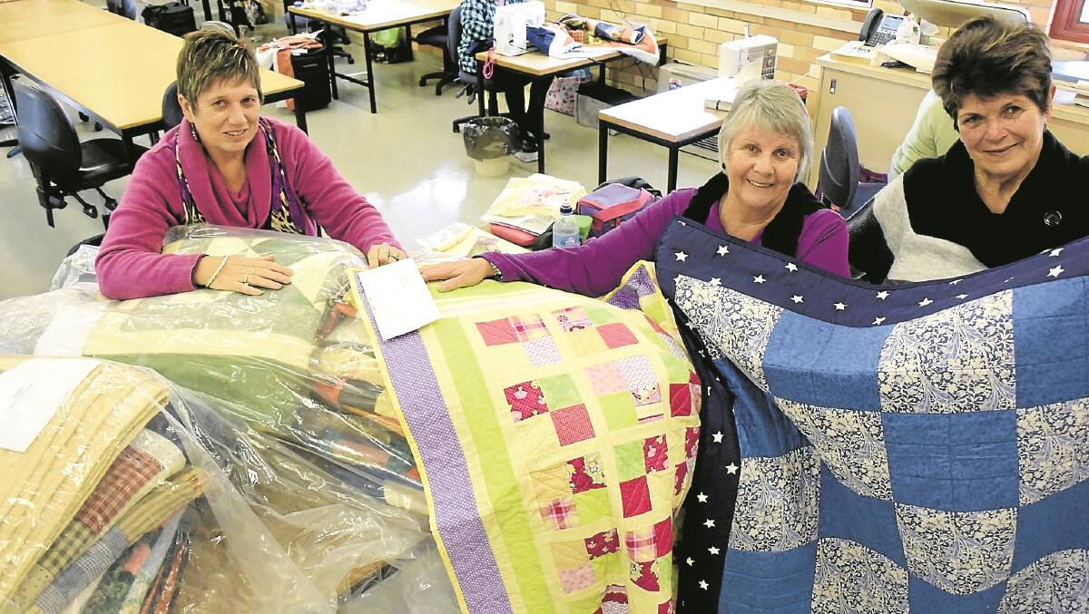MADE WITH LOVE: Fran Bulmer, Janel Holmes and Robyn Hill display some of their creations which have been sent to flood affected victims in Picton. 