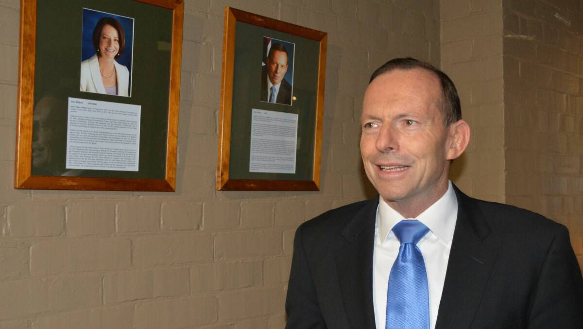 What's on your mind Mr Prime Minister? Abbott arrives at the School of Arts and surveys the wall commemorating past and present leaders.