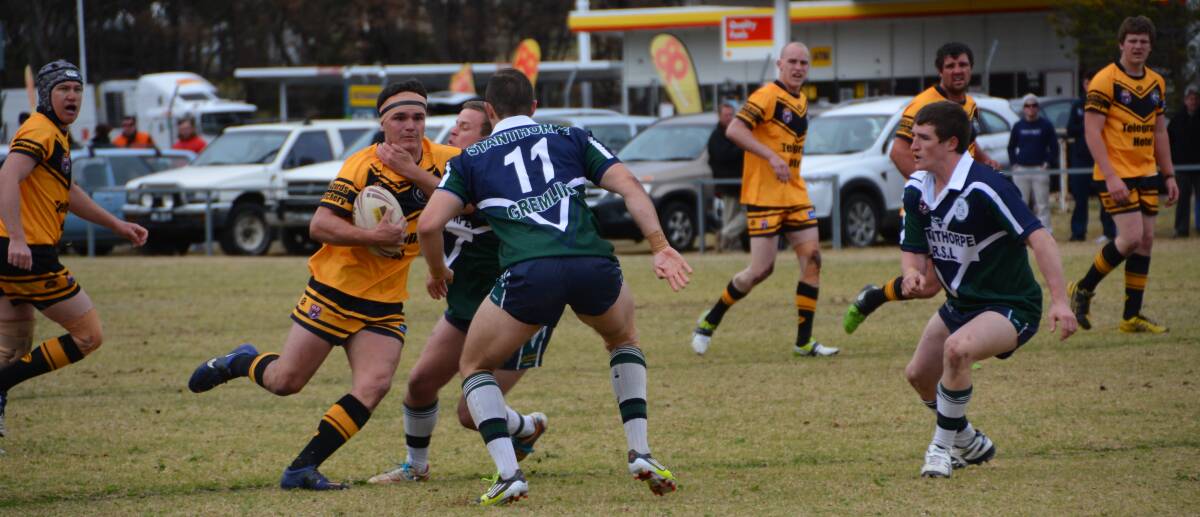 Tigers player Jim Loneragan tries to break free from the Gremlins defence.