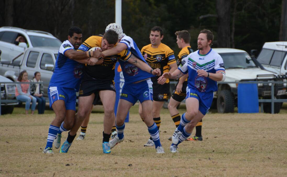 Tigers player Alex Duncan showing determination to bust through the Gremlins pack.
