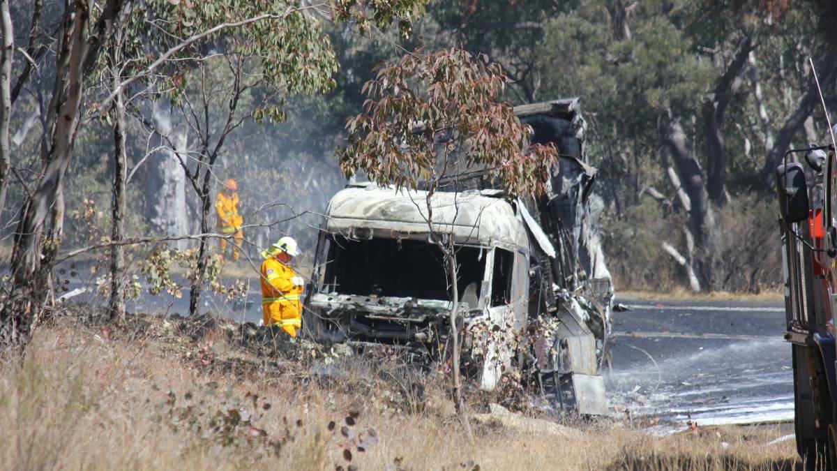 Fiery end: A RFS volunteer helps to extinguish the blaze that engulfed the truck. Photo: Madeline Link