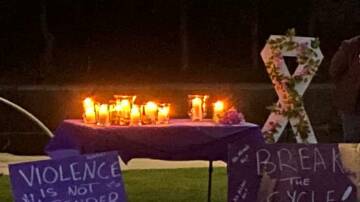 Candles flicker at the inaugural vigil to remember victims of domestic violence in Campbell Park, Inverell. The vigil was organised by Inverell's Rural Outreach and Support Service.