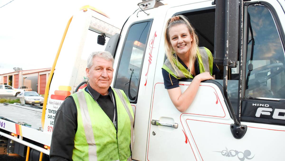 Bring it on: Tenterfield's newest tow truck operator Brittany Bates in 'Toby', her favourite tow truck, with dad and mentor Robert Bates. She relishes the challenge of sorting out the tricky situations she often encounters on retrievals. Photo: Donna Ward.