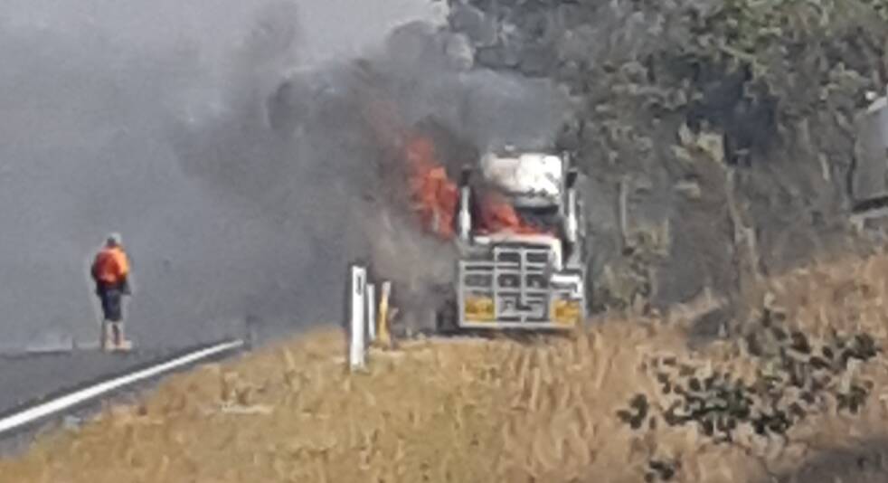 The cabin of a semi loaded with earthmoving equipment caught fire on the New England Highway near Tuesday night's outbreak.