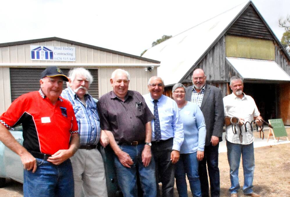 Pat Gillespie, Ian Docherty, Rex Holley, MP Thomas George, Anne Stackman, Tenterfield deputy mayor Greg Sauer and Edi Vah line up in front of the new and old Men's Sheds.