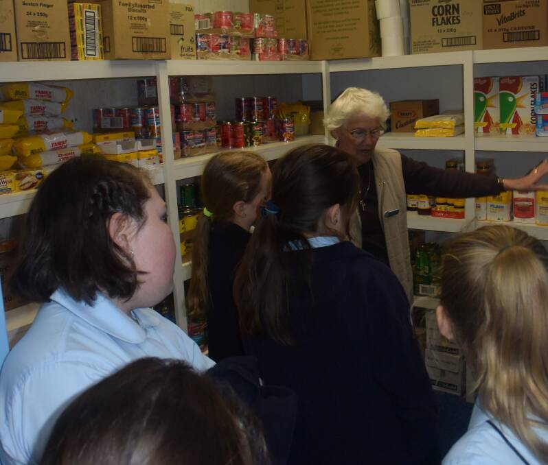 Marlene Feltis shows students around the food storeroom.