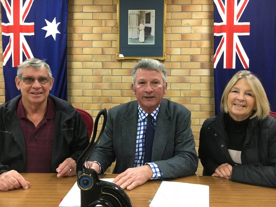 Tenterfield mayor Peter Petty signs the lease for the new field archery club, being orgnaised by Bob and Marian Rogan.