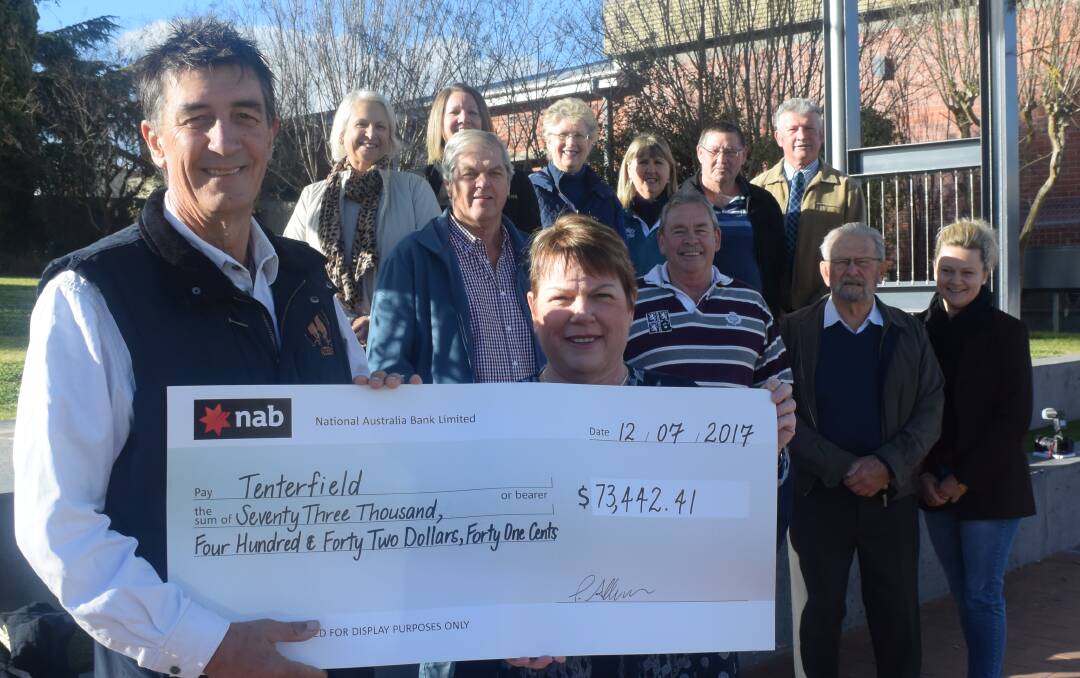 Tenterfield Chamber's Vince Sherry accepts the TDVA proceeds from Kim Rhodes, together with (at back, from left) Kim Massey, Nicole Rametta, Jenny Santin, Wendy Stranieri, Paul Quinn and Peter Petty, and (below) Peter Reid, Harry Bolton, Terry Kneipp and Lisa Curry.