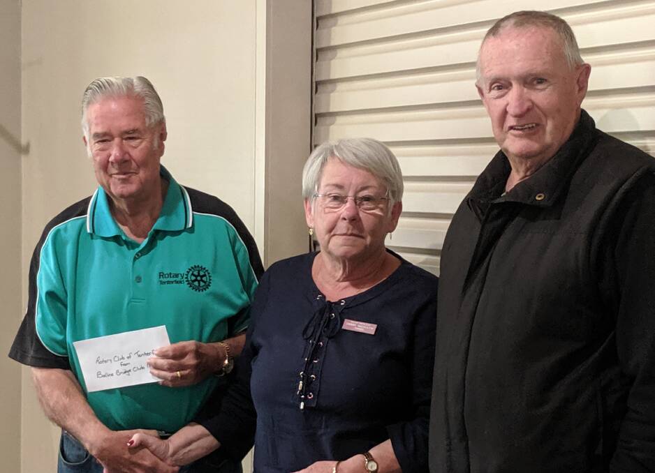 Ballina Bridge Club president Chery MaCallum presents a sizeable contribution to Tenterfield Rotary's water project, represented by Vice President Ralph Manser (on left) and Treasurer Kevin Rumble.