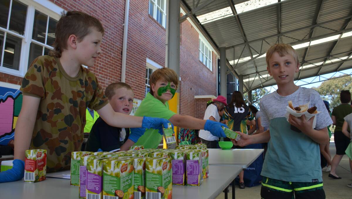 Archie (centre) works the production line along with helpers as students line up for their Belonging Day lunch.