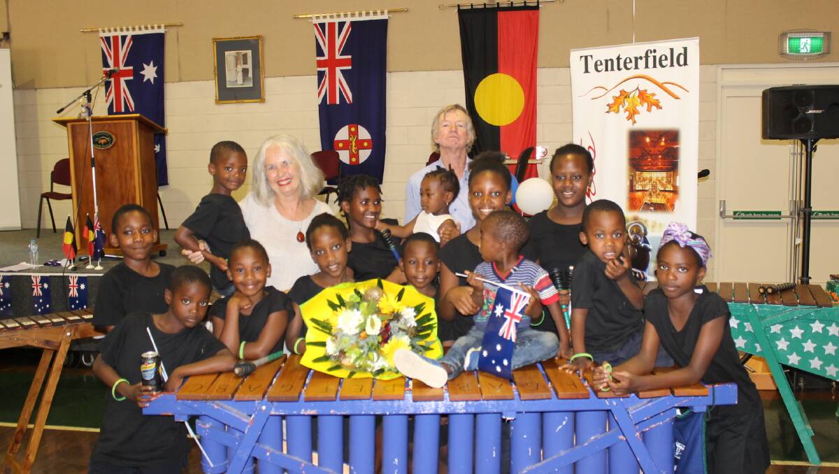 Julia Harpham with husband Philip and some of the refugee children now living in Mingoola, at the Australia Day ceremony in January.