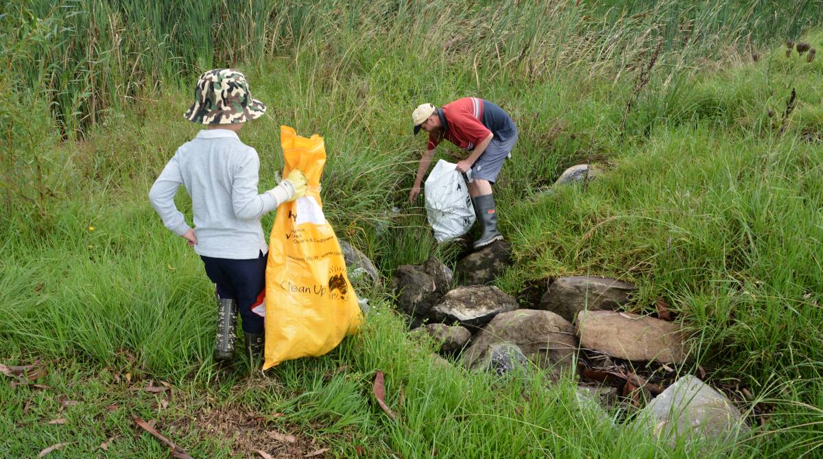 Dechlan King and dad Nicholas were among a handful of volunteers cleaning up Tenterfield Creek on Sunday.