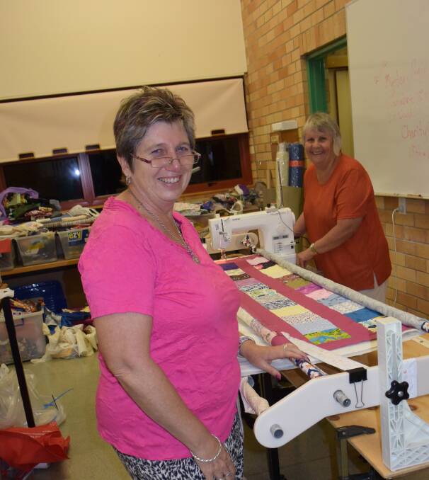 Fran Bulmer with Janel Holmes on the quilting machine, finishing off a quilt top that one keen participant completed in her 12-hour stint on the Saturday of the Quiltathon.
