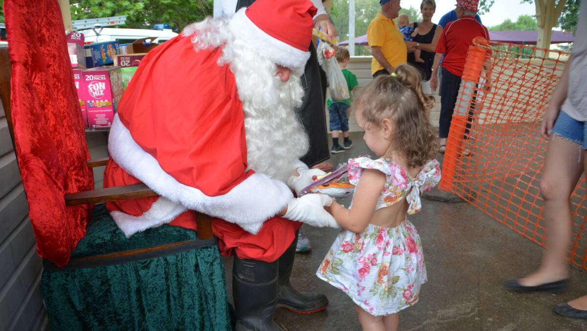 Santa's arrival is a highlight of any Christmas Carnival, as little Ahria Brown discovered last year.