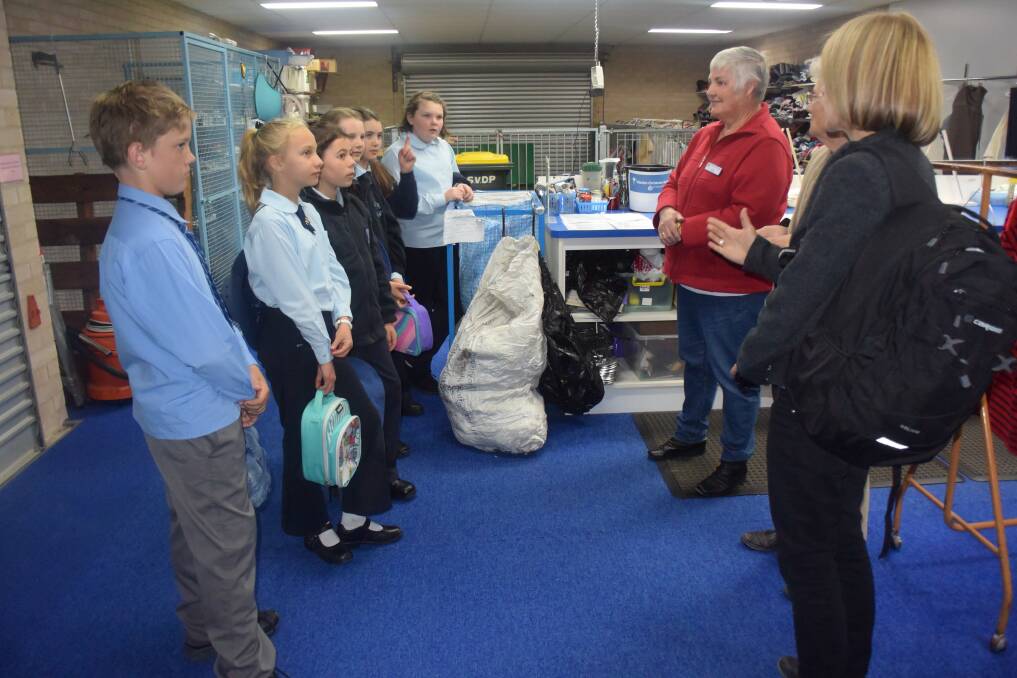 Back room operations of the St Vinnies Op Shop are explained to executive members of St Joseph's Mini Vinnies.