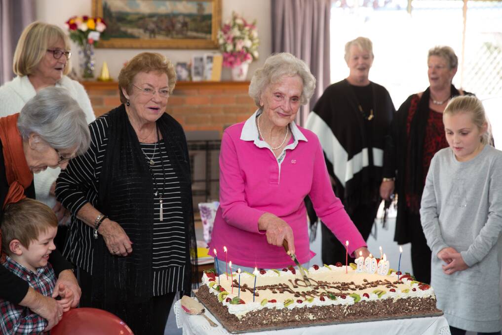 Mary Smith cuts her birthday cake on the day she turned 100. Photo by Peter Reid.