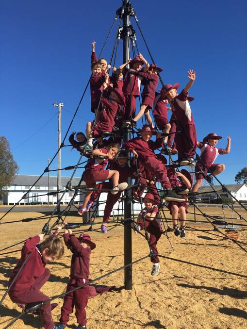 Wallangarra State School P12 students create a maroon tower on a visit to check out the new children playground alongside the Wallangarra Hall.