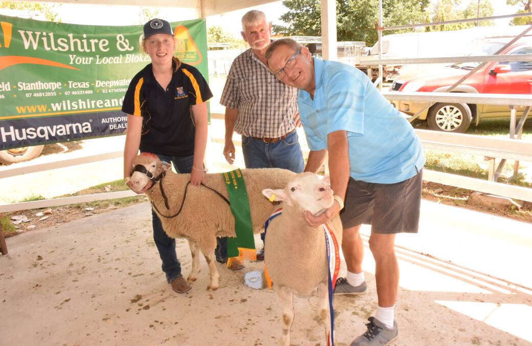 Champion prime lamb held by exhibitor was won by Don (on right) and Sandie Iedeme, with reserve champion won by the Tenterfield High School team represented by Bronte Sharpe. Judge Joe Browne is in the centre.