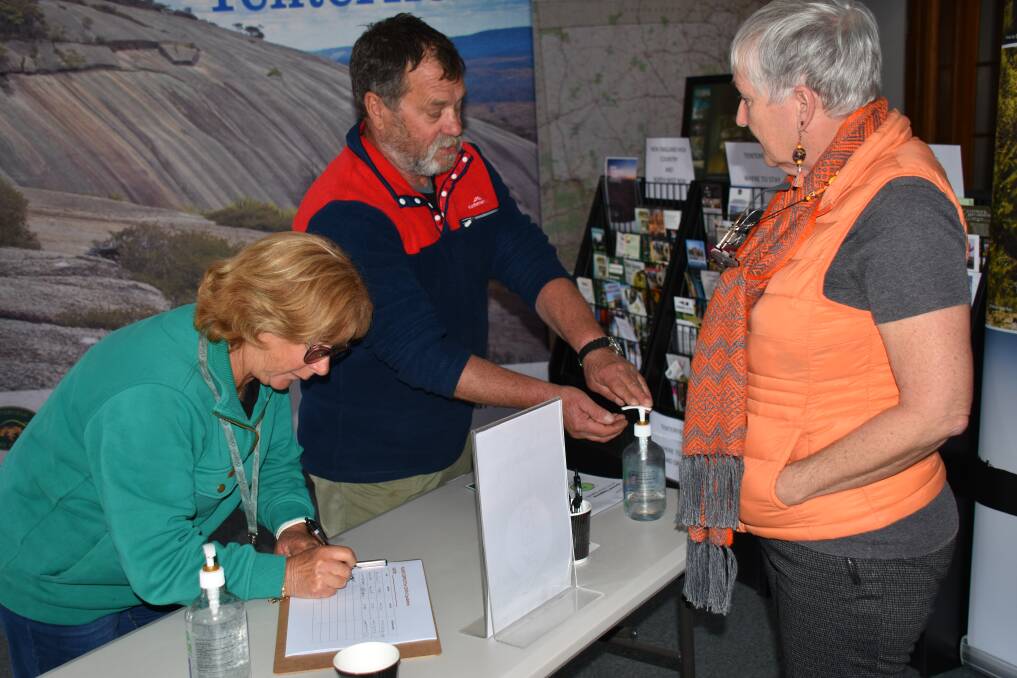 Victorians Elizabeth and Bryne Fowler had been travelling around NSW for a month before signing in and sanitising at the Tenterfield Visitor Information Centre, as tourism officer Charlie Main provides some local knowledge.