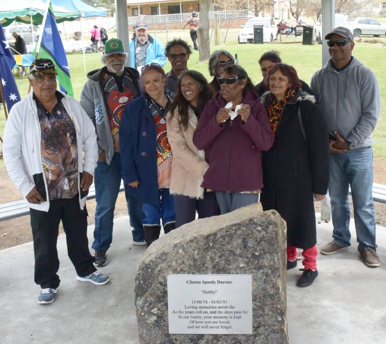 GONE BUT NEVER FORGOTTEN: Clinton Speedy-Duroux's family gathers around his memorial.