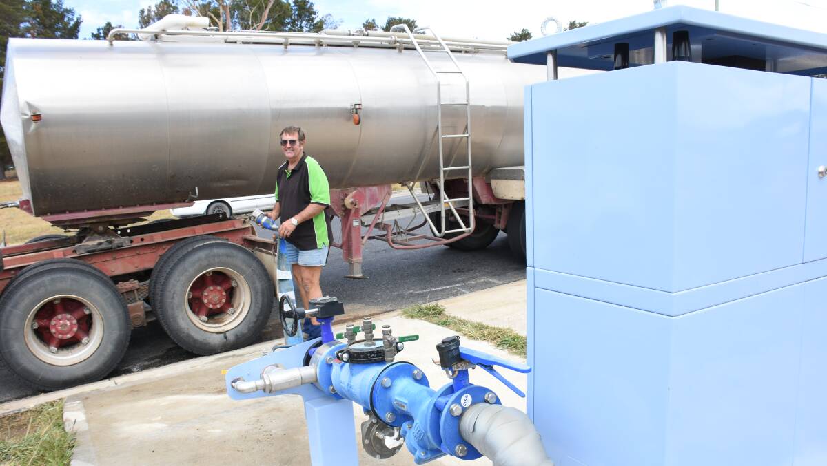 Water carter Col Graham pumps out another load of potable water from the water dispensing station in Riley Street.
