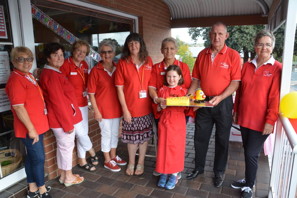 (From left) Ellen Kelly, Marie Petrie, Susan Williams, Margaret Cooper, Michelle Ortega, Lucy Preece, 'Dodge' Landers and Roni Foster celebrate the Op Shop's second birthday in Tenterfield, with Ruby Galvin holding the birthday cake.