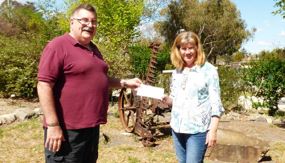Super Saturday organiser Barry O'Connor hands over the proceeds to Tenterfield Community Church's Pam Sammut for distribution to bushfire victims.
