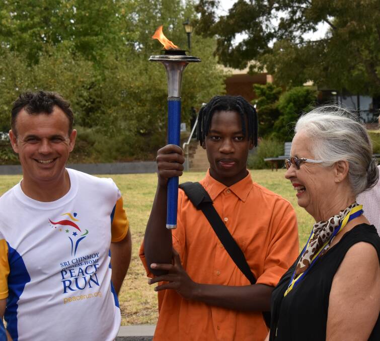 Ezekia Nitanga, one of the refugees helped by the Harphams, gets to hold the Torch of Peace, lit briefly for the occasion.