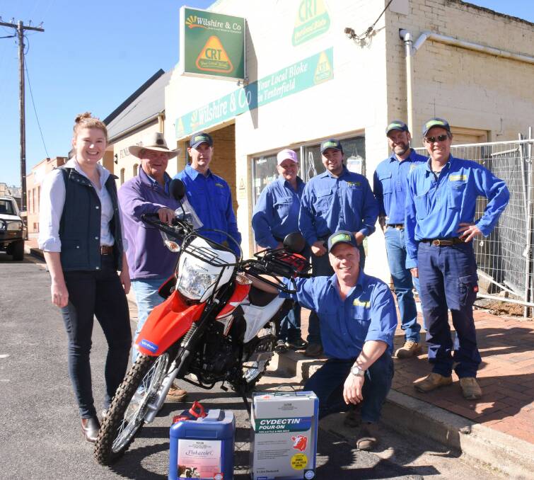 If only it stayed so new and clean: Lined up around Knockdon Park's new farm bike are (from left) Virbac SEQ livestock sales manager Jess McGrath, winner Paul McFarlane, and Wilshire & Co's Rex Richards, Anna Hudson, Joe Roots, Simon Piccini, Dave King and (kneeling) Todd Wilshire.