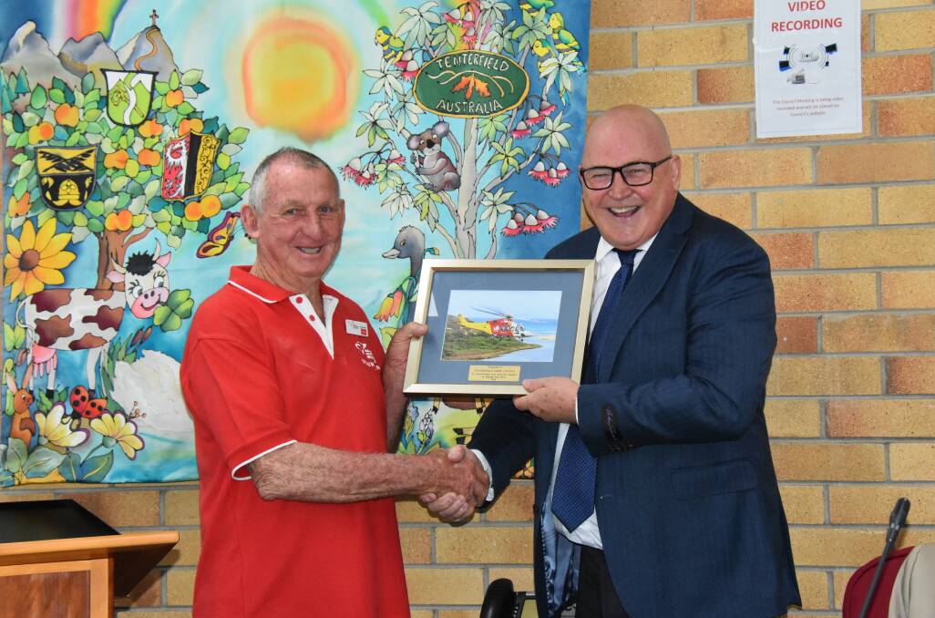 Westpac Rescue Helicopter Support Group president John 'Dodge' Landers presents deputy mayor Greg Sauer with a memento of thanks for council's support.