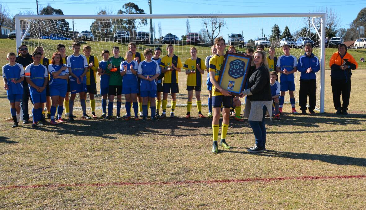 Stanthorpe Inter captain Dan Davis receives the Brendan Sweetman Cup from Leighanne Sweetman at the conclusion of Saturday's game. Photo by Melinda Campbell.
