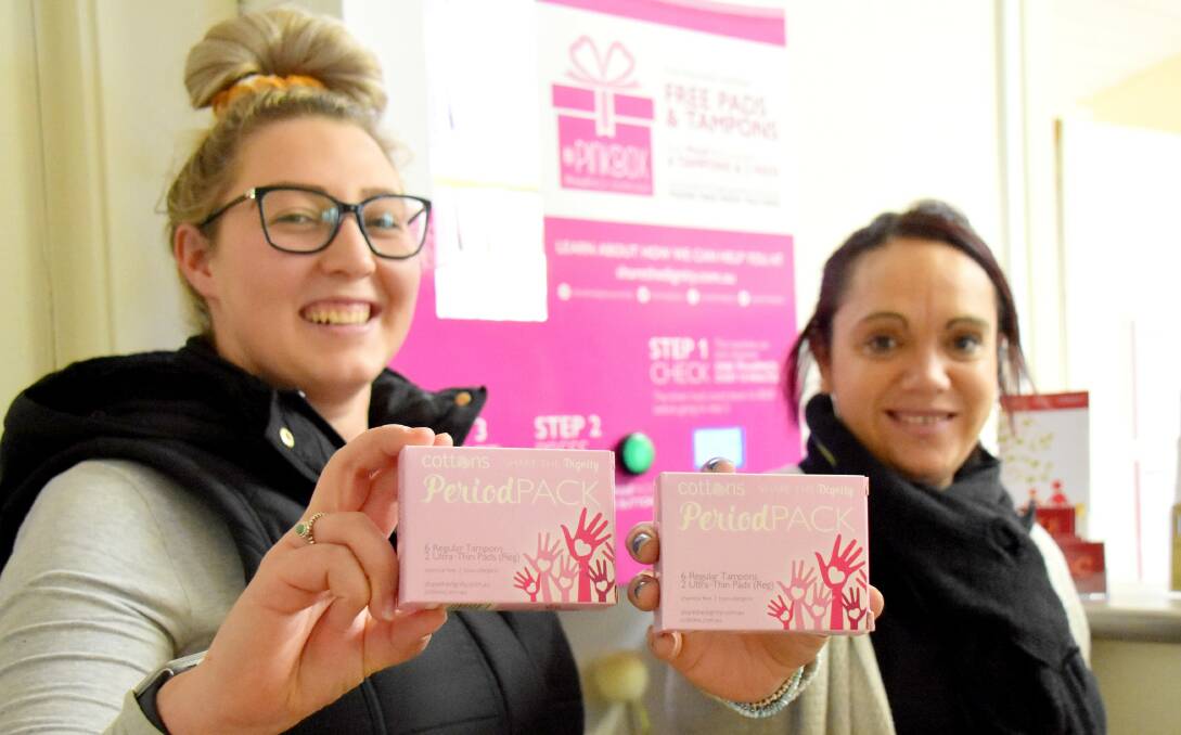 Billie-Anne Flint and Shahan McIntosh of Tenterfield Social Development Committee with the free sanitary products available through the service's dispensing machine.