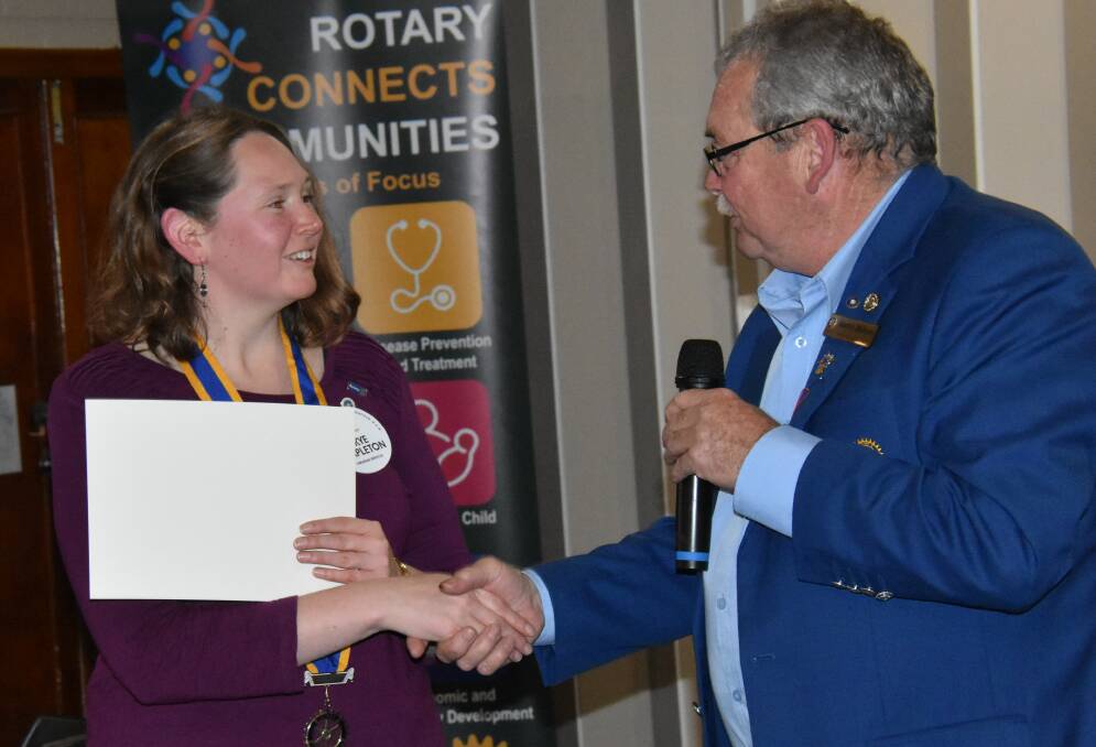 Skye Stapleton, being congratulated by soon-to-be district governor Harry Bolton, now moves into the position of immediate past president.