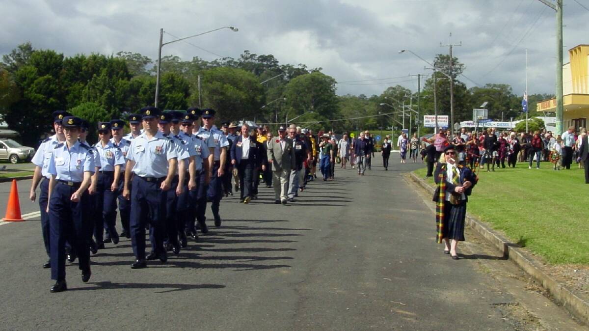 Bagpiper Christine Reid with 1Squadron RAAF Amberley Members head the march at Woodenbong ANZAC Day Commemorations.