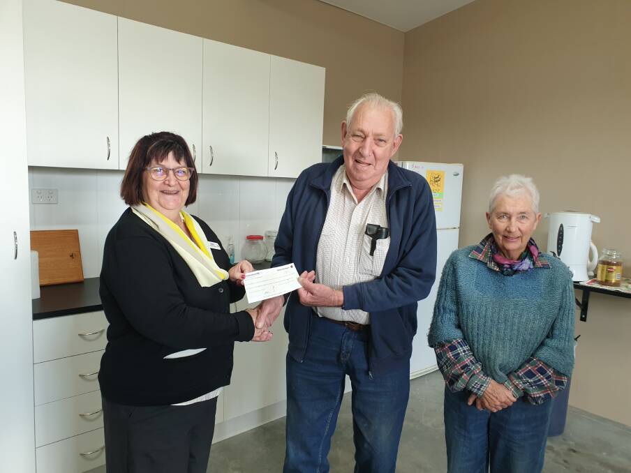 Commonwealth Bank manager Debbie Minns hands over a $500 community grant to Tenterfield Mens Shed members Rex Holley and Mignon Wanstall.