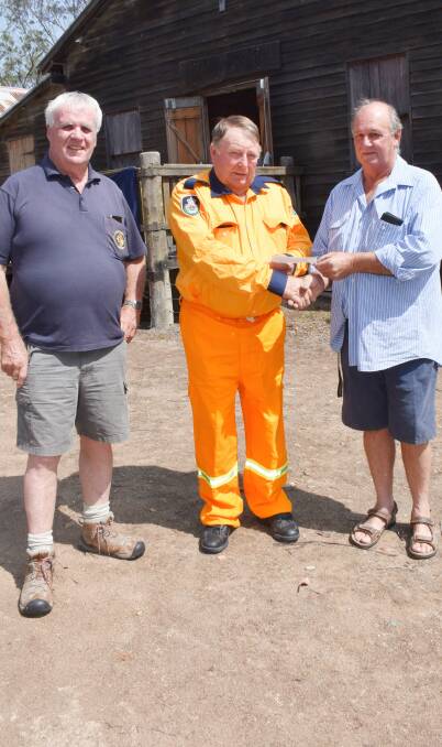 John Macnish looks on as Steinbrook RFS brigade's Bruce Petrie happily accepts the donation from Steinbrook Progress Association vice president Rod Taylor.