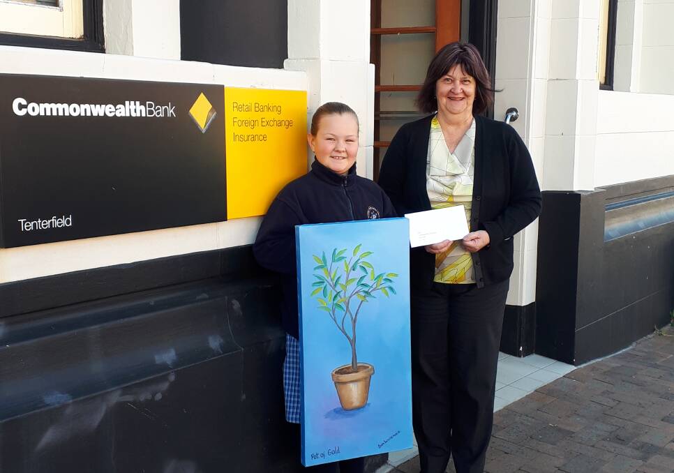 TSHPMPS student Taneeka presents Commonwealth Bank branch manager Debbie Minns with a token of thanks for the bank's support of the school's Native Garden Gateway project.