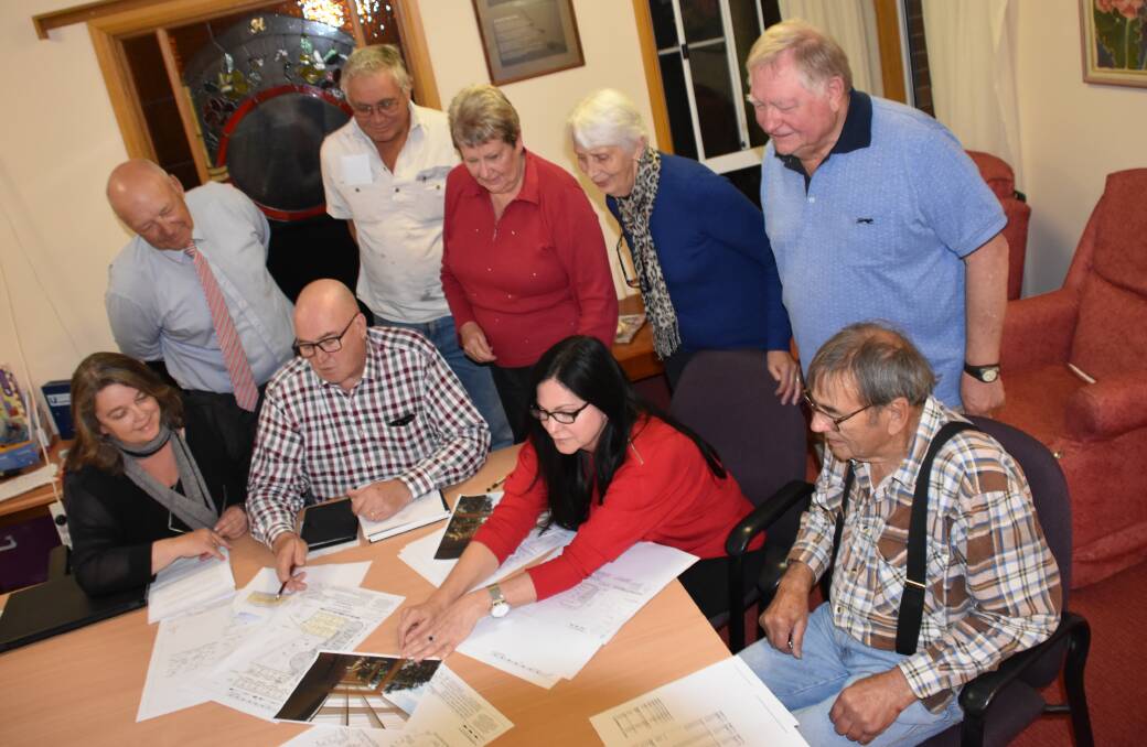Tenterfield Care Centre board members (with chair Greg Sauer and general manager Fiona Murphy seated centre) pour over the plans for the new Haddington extension, which have now been approved to progress to the next stage.