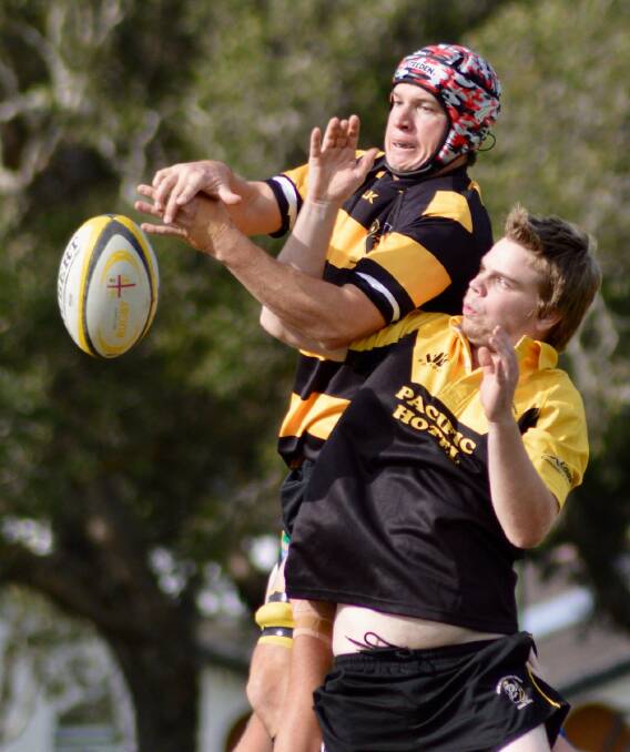 Nick Lanz battles with a Yamba player for the ball. Photo: Graham Mackie. 