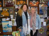 Loz Lavea with one of the organisers, Kristen Lovett, and some of the auction items.